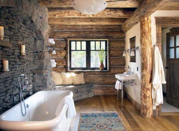 Rustic bathroom with stone walls, a wooden bathtub and sink, plus a window for natural light