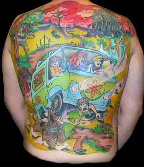 Full back tattoo of the Scooby-Doo gang in the Mystery Machine with Shaggy and Scooby running from ghosts in a haunted landscape.