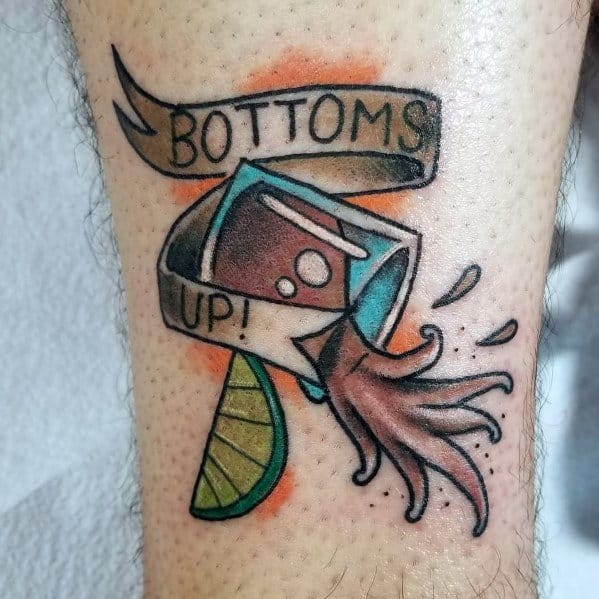 Colorful shot glass tattoo with a "Bottoms Up!" banner, lime wedge, and liquid splashing out, creating a bold and dynamic design.