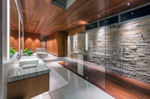 Elegant modern bathroom with stone wall, sleek shower, and soft ambient lighting highlighting the space