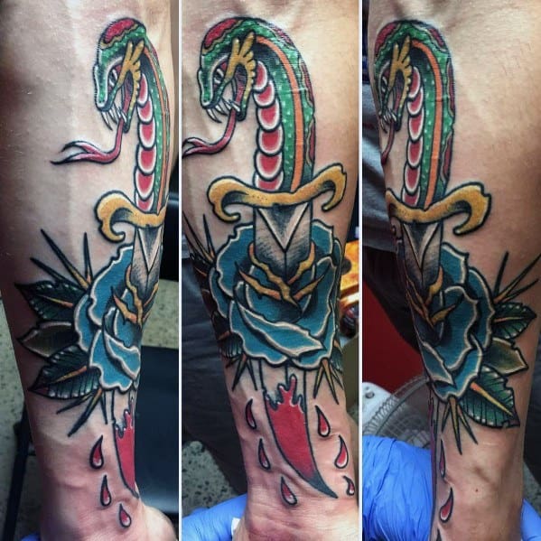 Colorful snake and dagger tattoo on forearm, featuring a blue rose, blood drops, and bold traditional-style shading and outlines.