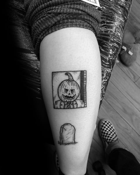 Black and white tattoo featuring Dwight Schrute with a pumpkin on his head from The Office, along with a small gravestone below it.