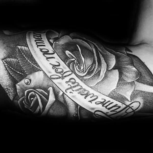Tattoo featuring detailed black and grey roses with a banner wrapping around them that reads Time Waits for No Man.