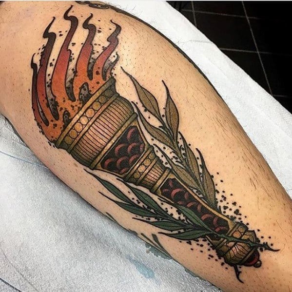 Traditional style torch tattoo with orange flames, leafy elements, and bold dotwork shading on the outer calf.