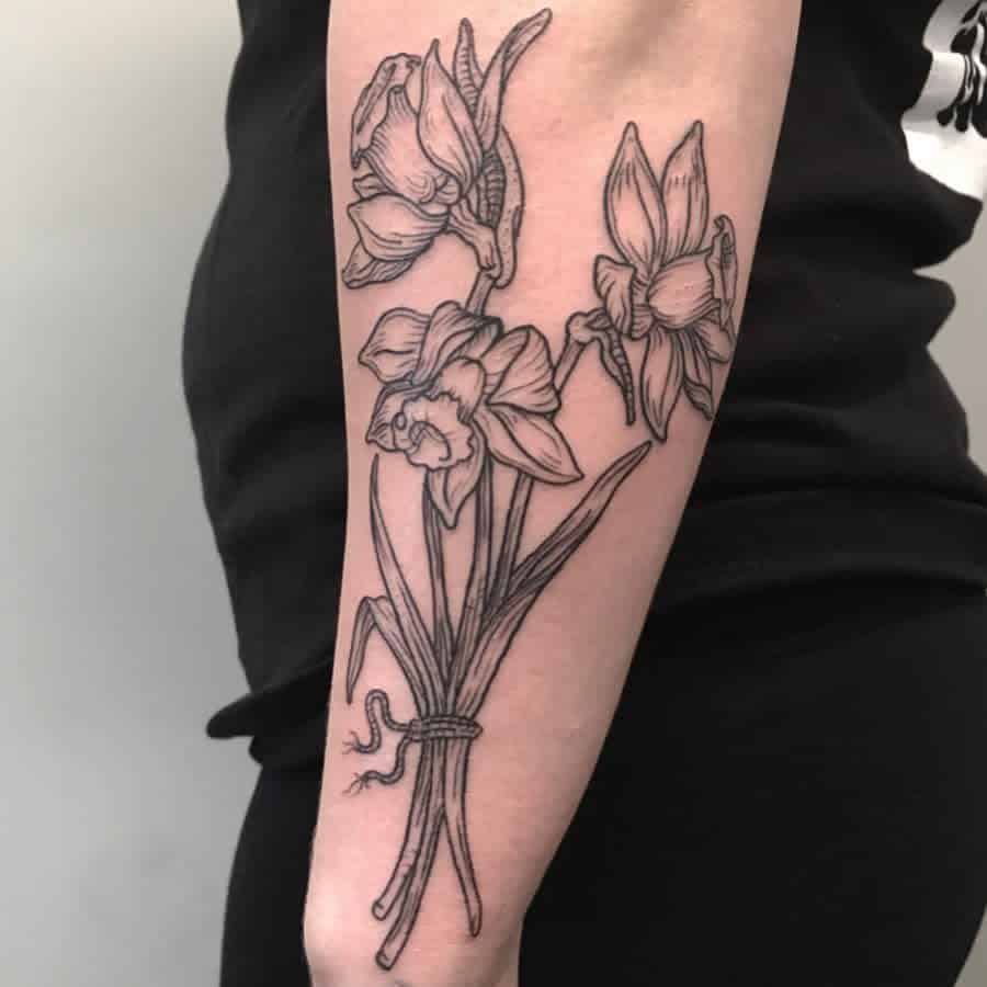 A detailed black-and-white tattoo of a bouquet of daffodils, elegantly tied together with a string, highlighting the delicate structure of the flowers and leaves.