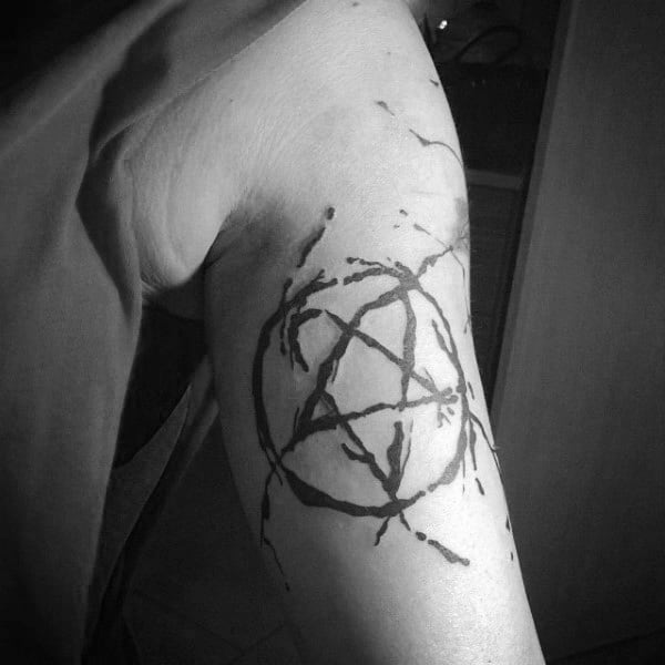 Black ink pentagram tattoo with an abstract splatter design