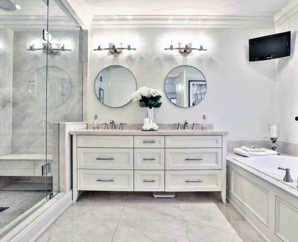 Elegant bathroom with a white double vanity, mirrors, flower vase, shower, and a bathtub