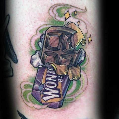 Willy Wonka tattoo of a partially unwrapped Wonka Bar with golden sparkles and green swirling background.