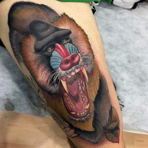 Realistic baboon tattoo with fierce open-mouthed expression, rich shading, and vibrant facial colors, creating a bold and dynamic leg design.