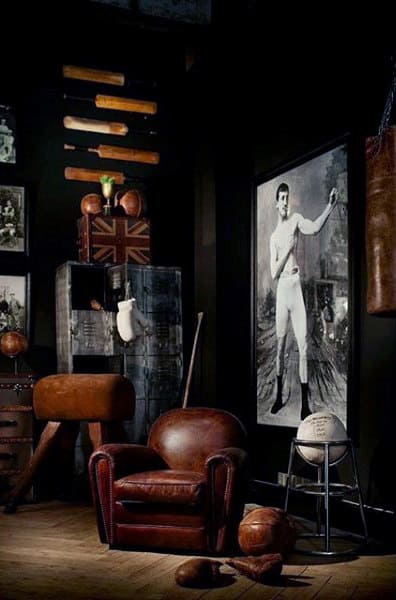 Vintage-inspired bachelor pad with leather chair, boxing gear, and framed artwork.