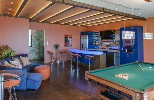 Man cave with a pool table, cozy seating, bar area, and modern lighting