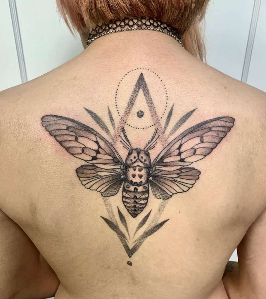 Geometric back tattoo of a cicada with intricate wings, accented by dotwork patterns and symmetrical shapes