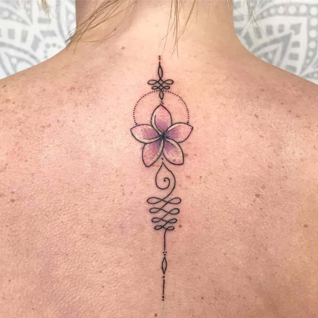 A delicate back tattoo featuring a single Plumeria flower with subtle pink hues, surrounded by intricate geometric and ornamental linework for a minimalist and elegant design