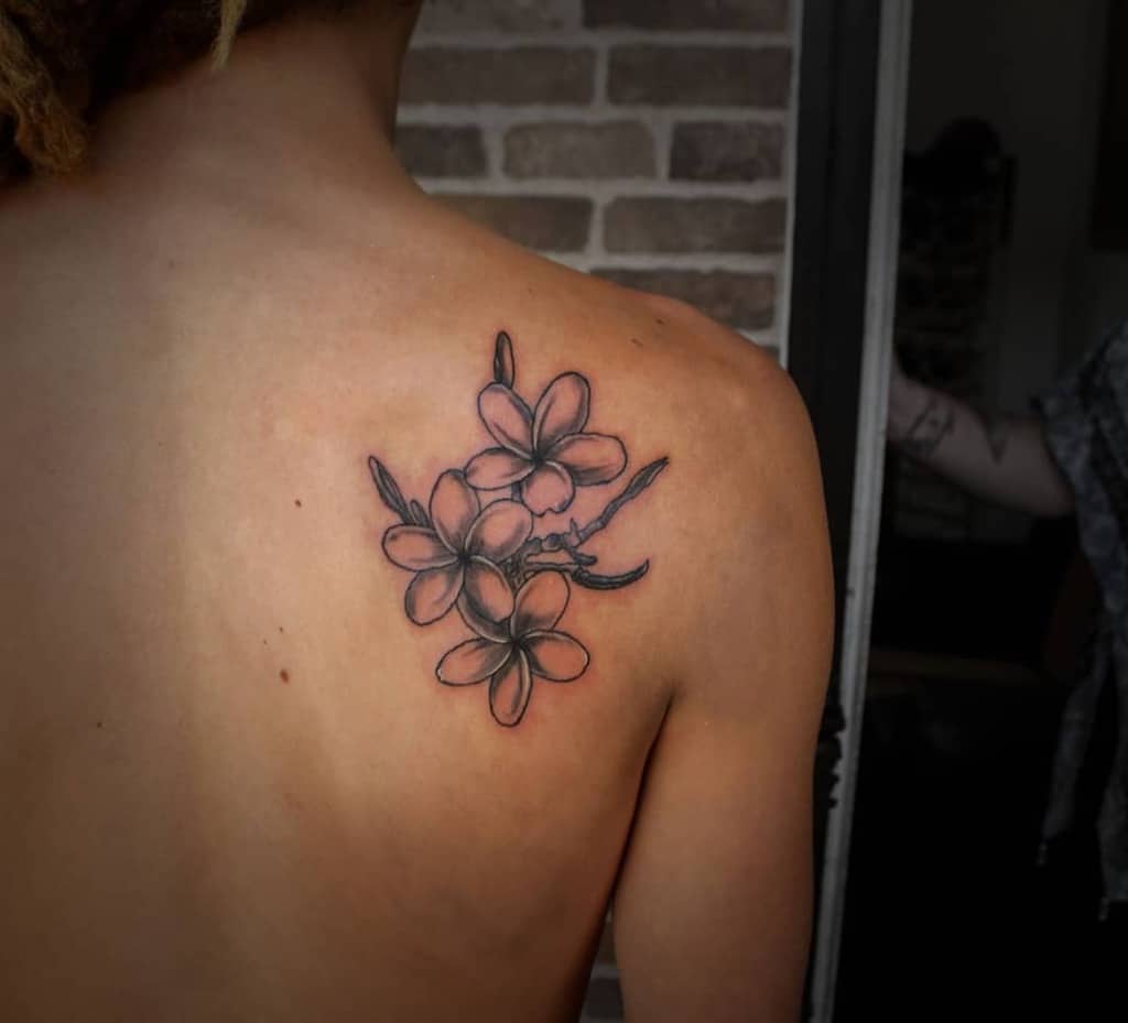 Back with a shaded plumeria flower tattoo near the shoulder blade