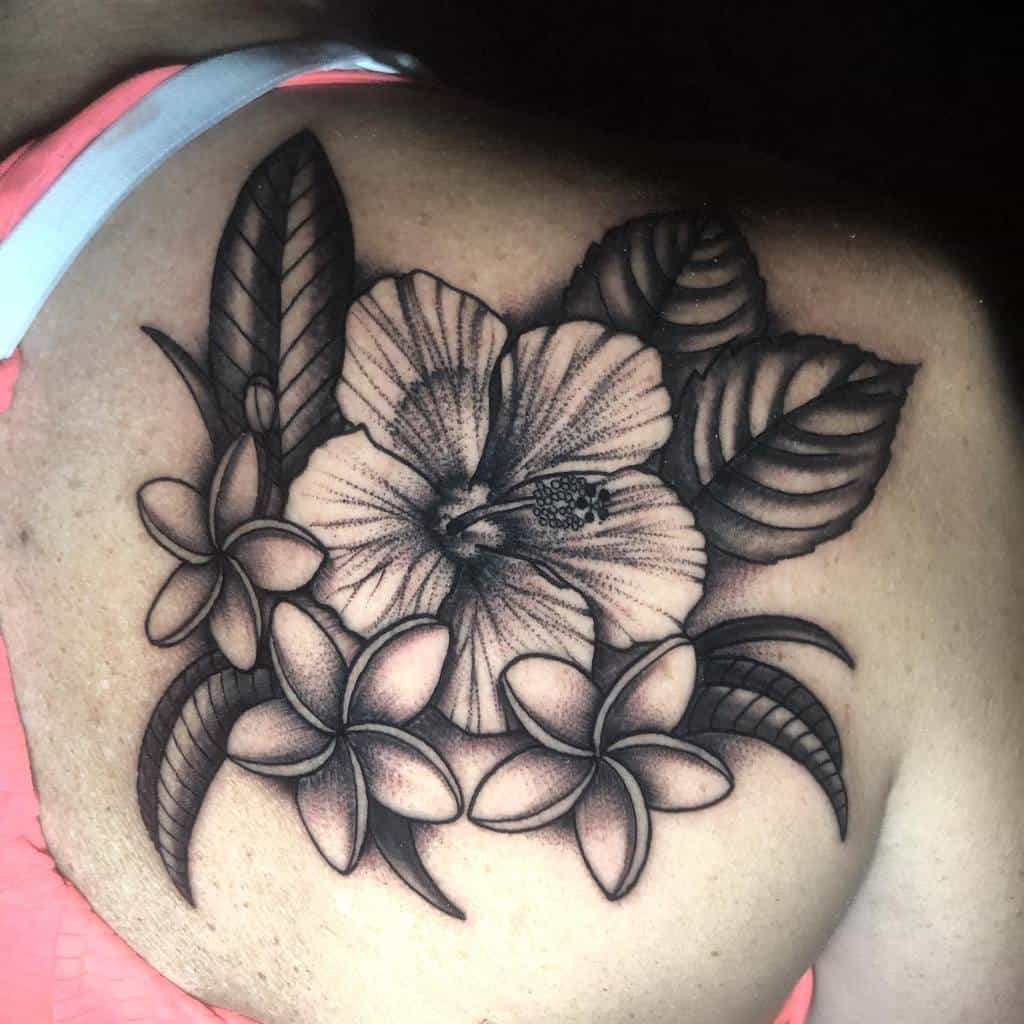 Beautiful back tattoo showcasing a combination of Plumeria flowers and a detailed hibiscus, surrounded by intricate leaf patterns, creating a harmonious tropical design