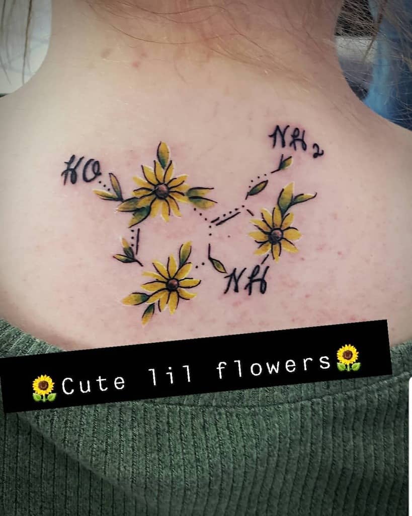 Tattoo of yellow flowers intertwined with serotonin's chemical structures on back