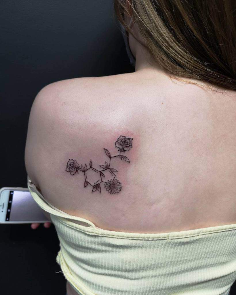 A tattoo of flowers blooms across a person's shoulder, capturing the essence of serenity
