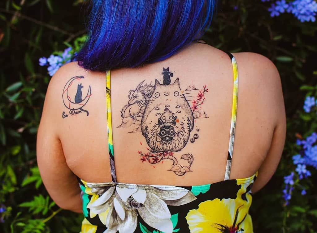 Intricate Totoro back tattoo featuring Totoro, soot sprites, cherry blossoms, and additional Ghibli characters in a delicate linework style