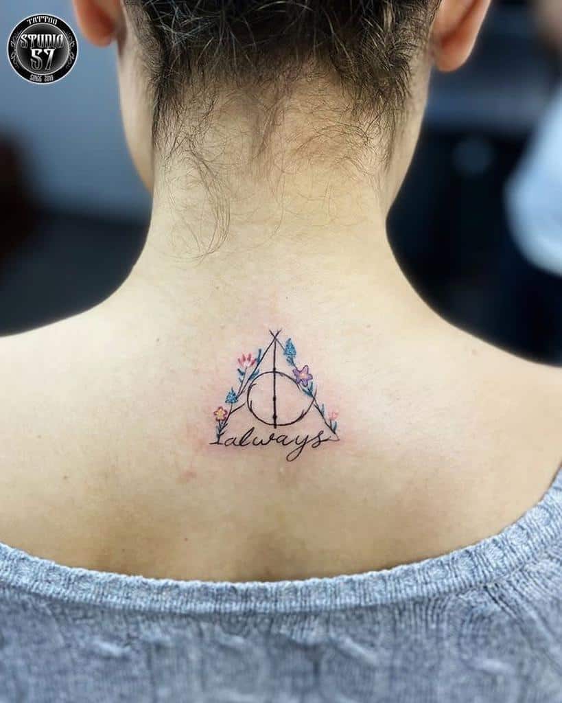 Harry Potter-inspired back tattoo with the Deathly Hallows symbol, floral accents, and 'Always' in delicate cursive