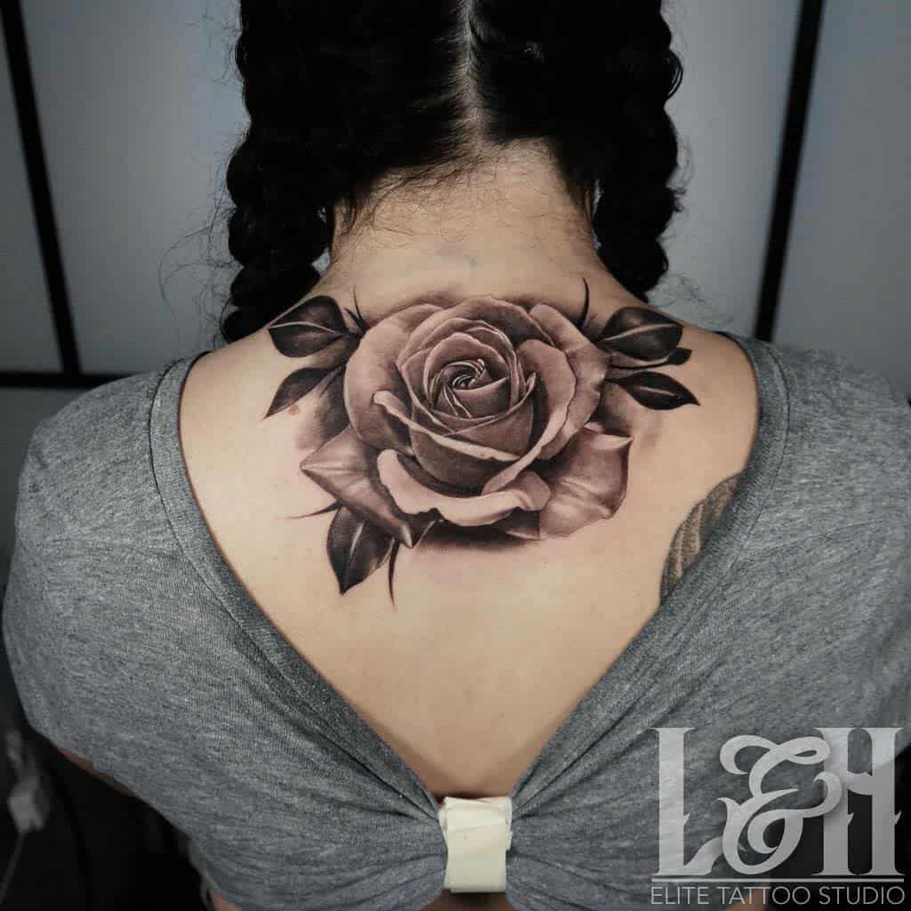 A woman with a large rose tattoo on her upper back