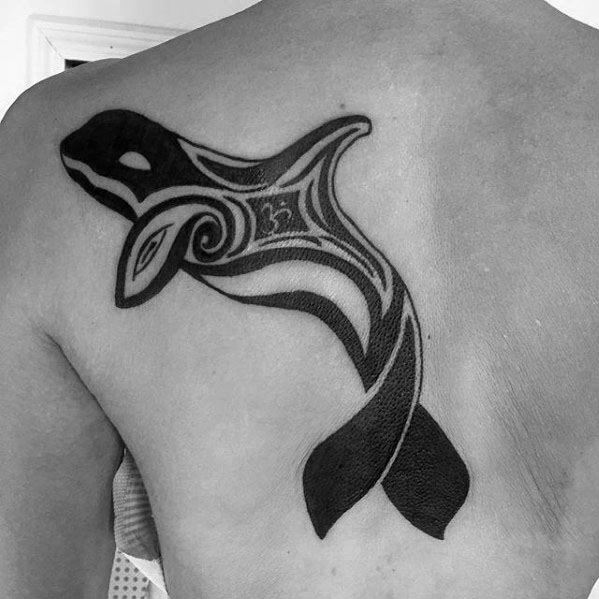 Bold black tribal-style orca tattoo on the back, featuring fluid lines and intricate patterns, creating a dynamic and symbolic representation of the whale.