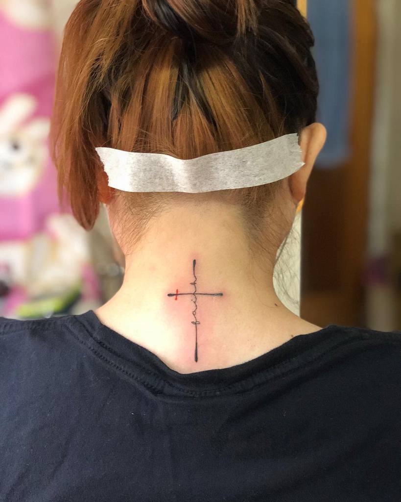 A woman with a cross tattoo symbolizing faith adorns their neck
