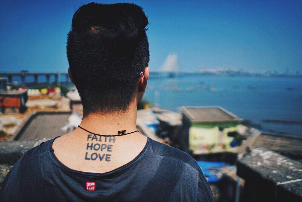 A man with a "Faith Hope Love" tattoo on the back of neck
