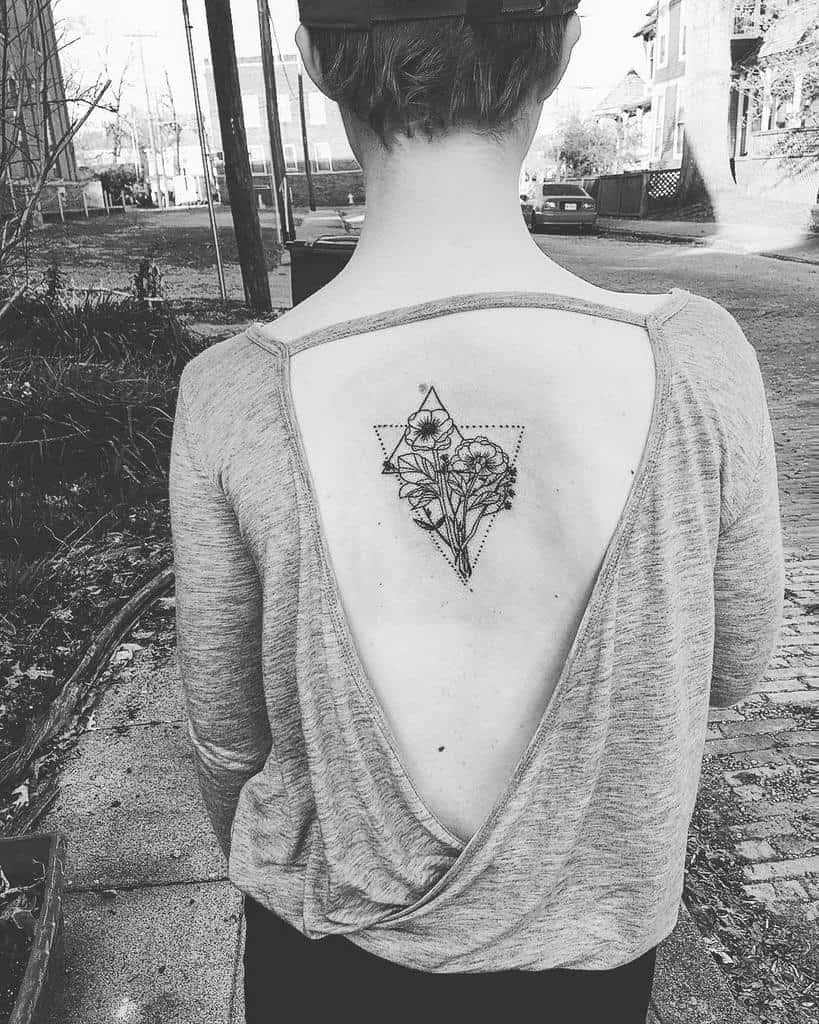 Geometric flower tattoo on the upper back, featuring a combination of delicate floral designs inside a triangle and dotted lines