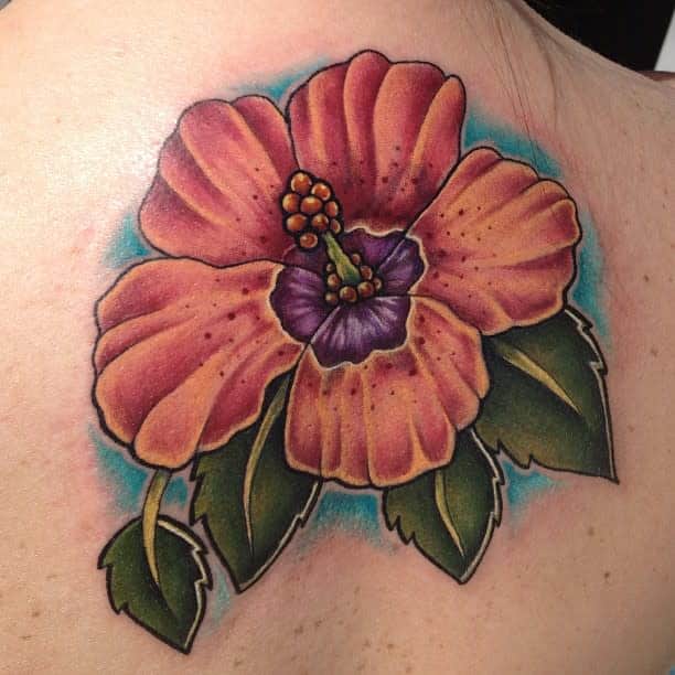 Colorful hibiscus flower tattoo with green leaves on skin