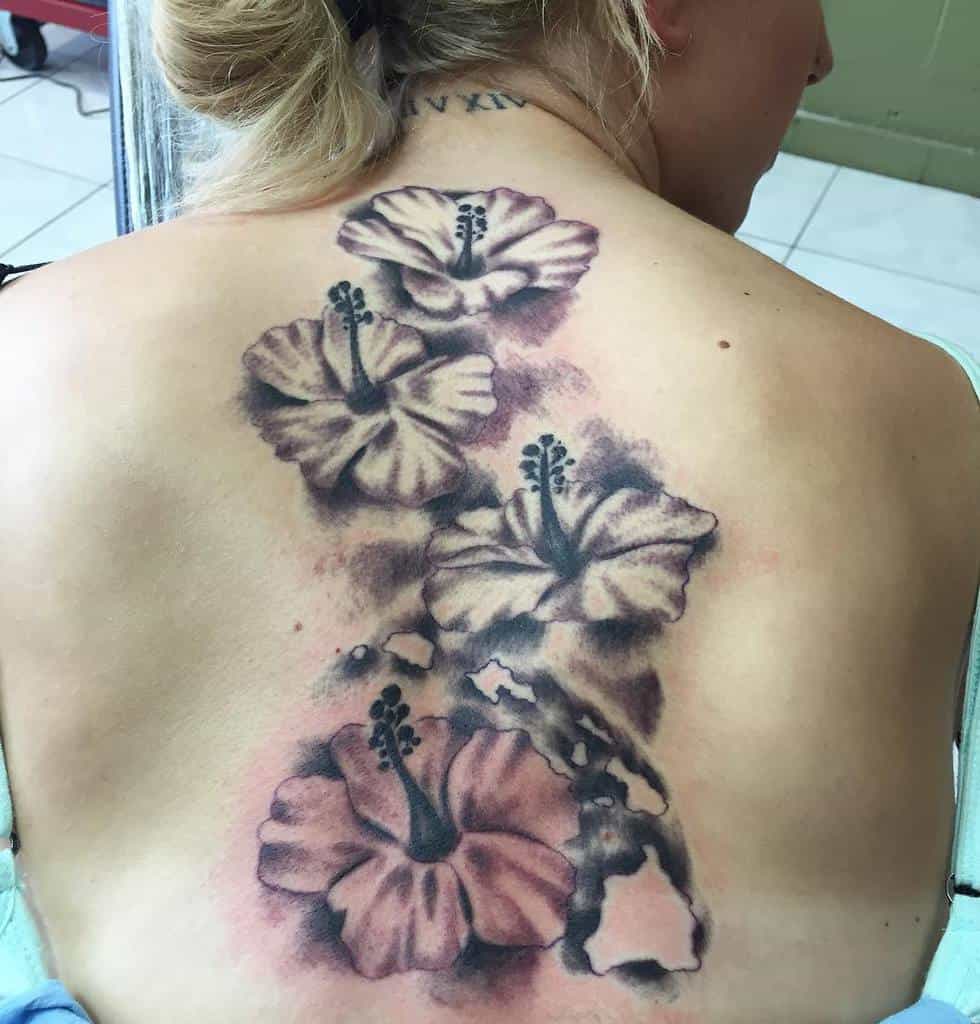Large flower tattoo covering the back, with four prominent blossoms