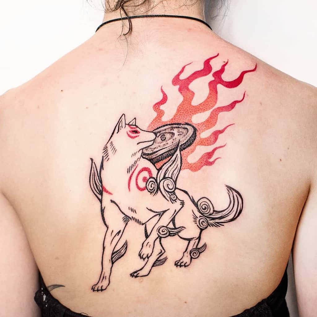 A back tattoo featuring a stylized Japanese wolf adorned with red markings and a flaming disc on its back