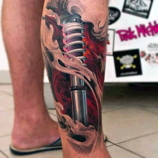 Leg tattoo with a detailed shock absorber design surrounded by flames