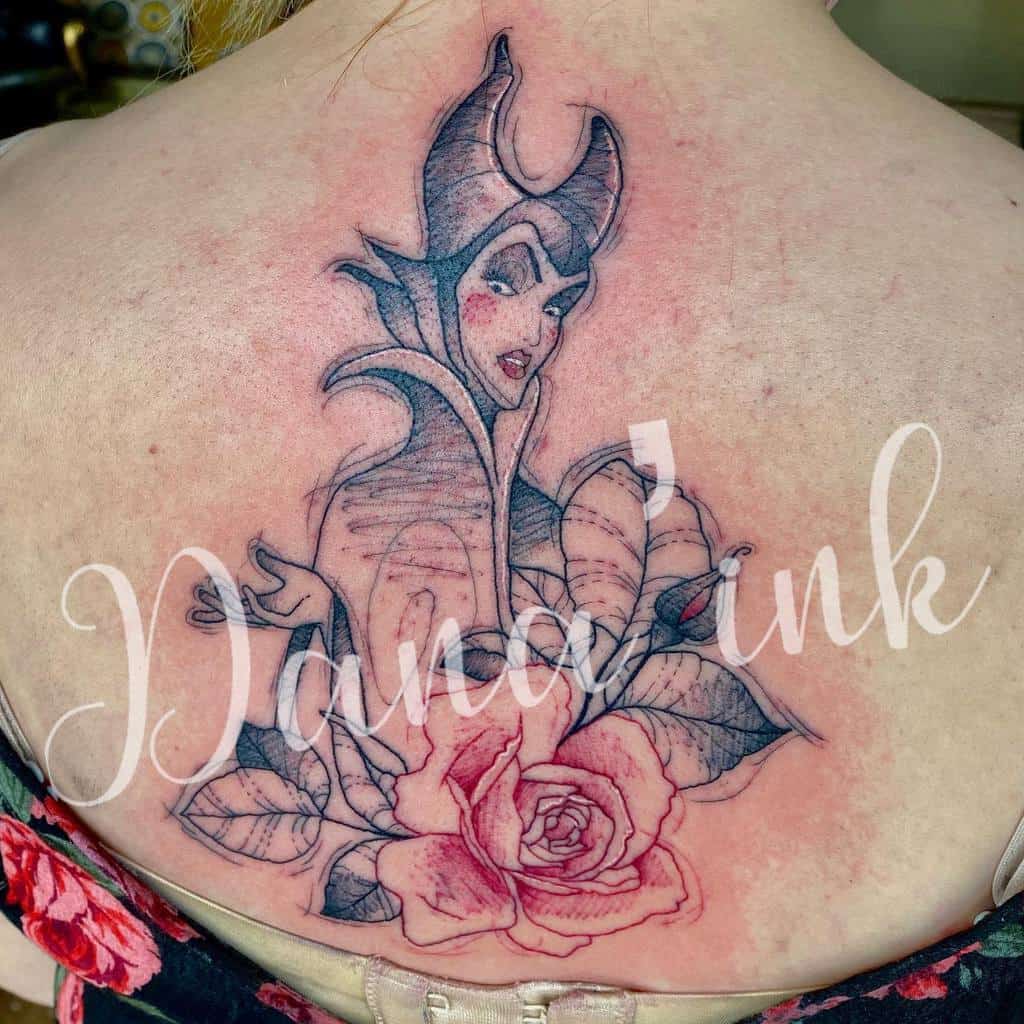 Tattoo of a villainous Maleficent character with horns and a rose on a an upper back