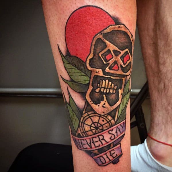 Colorful traditional-style tattoo inspired by The Goonies, featuring a stylized skull, red sun, leaves, and a banner reading "Never Say Die".