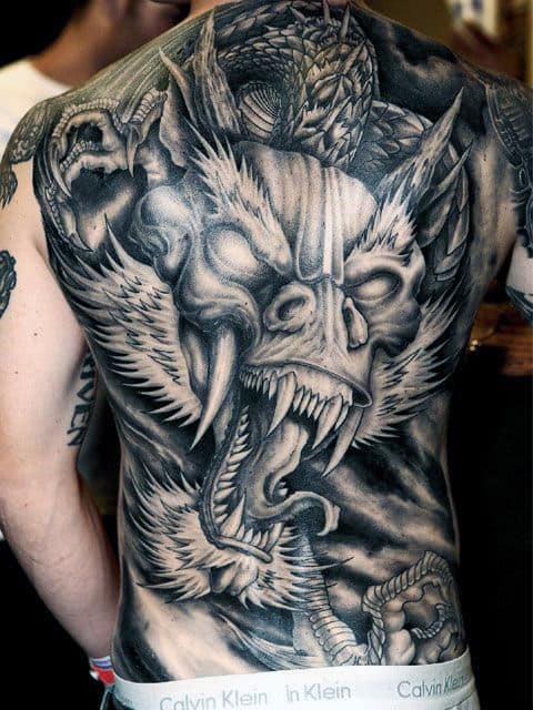 Full back tattoo featuring a roaring, winged creature with sharp teeth and claws