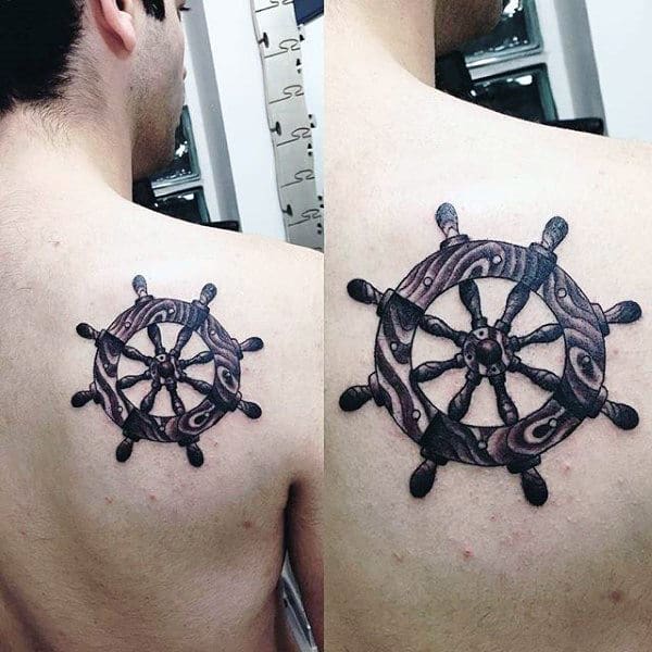Back Of Shoulder Ship Wheel Tattoo On Man With Black Ink