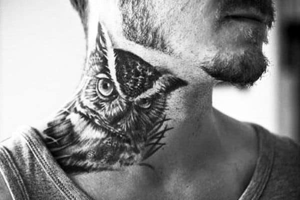 Neck tattoo of an owl on a man with facial stubble