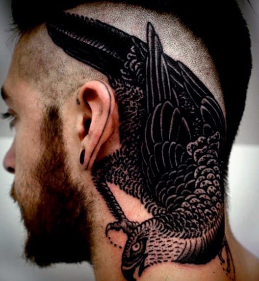 Man with a detailed black bird tattoo on the side of his head and neck