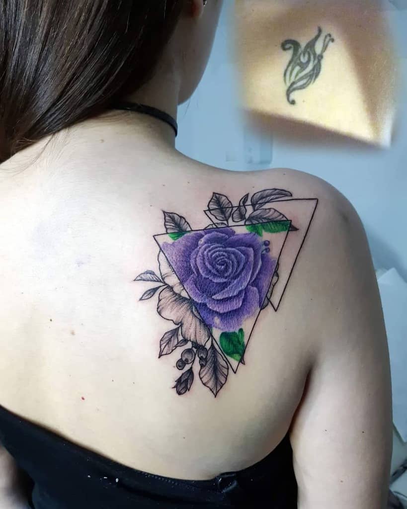 A woman displays a striking tattoo on her upper back, featuring a purple rose gracefully intertwined within intricate geometric shapes