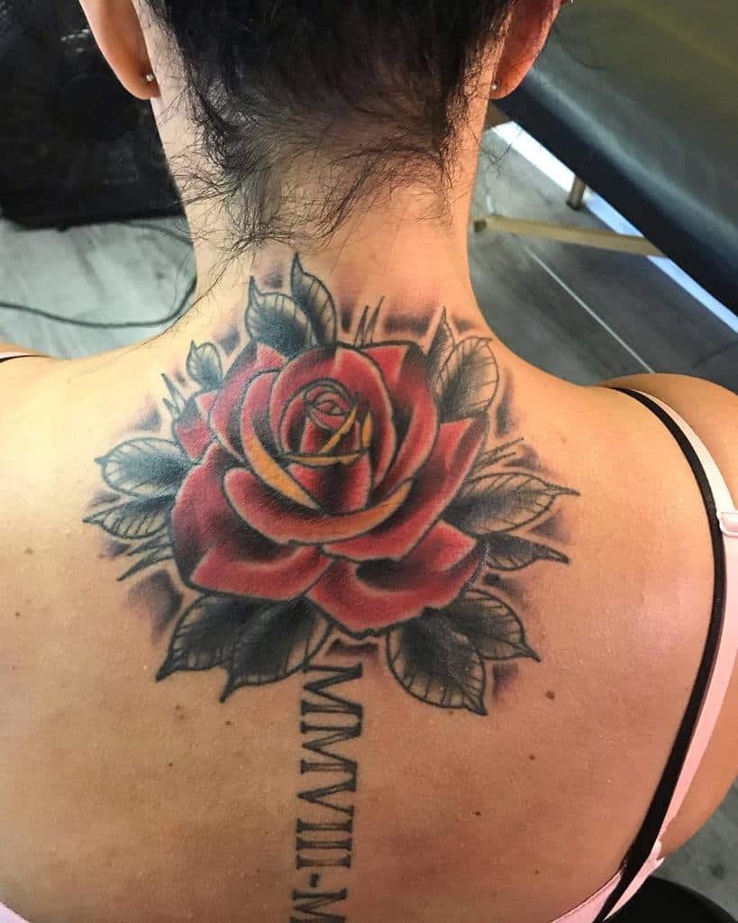 A stunning large red rose tattoo graces the woman's upper back and neck, its vibrant petals capturing attention and admiration