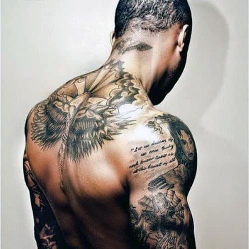 A shirtless person with elaborate tattoos covering their back and arms