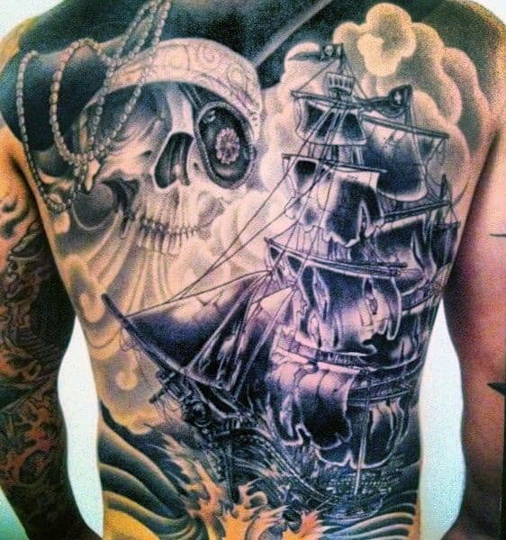 A detailed back tattoo of a pirate ship and a skull wearing a hat with a chain