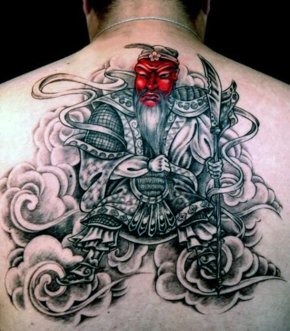Tattoo of a warrior in traditional attire with a red face on a person's back
