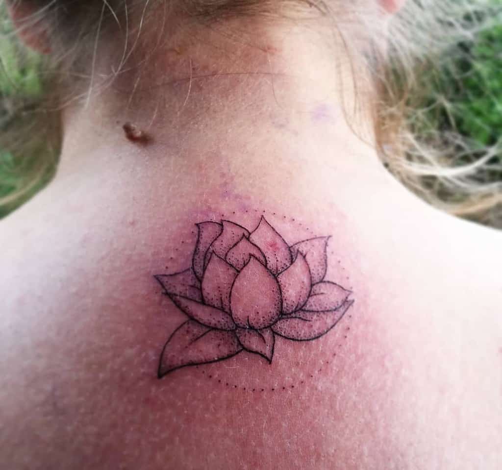 A line art tattoo of a lotus flower on the back of a neck