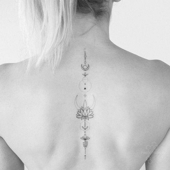 Unalome tattoo with a lotus and celestial elements on the spine, symbolizing spiritual growth, enlightenment, and cosmic harmony.