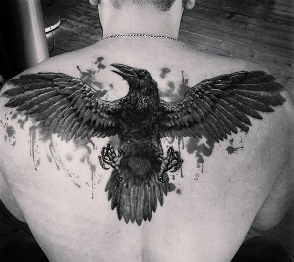 A tattoo of a large, detailed raven with open wings spans across an upper back