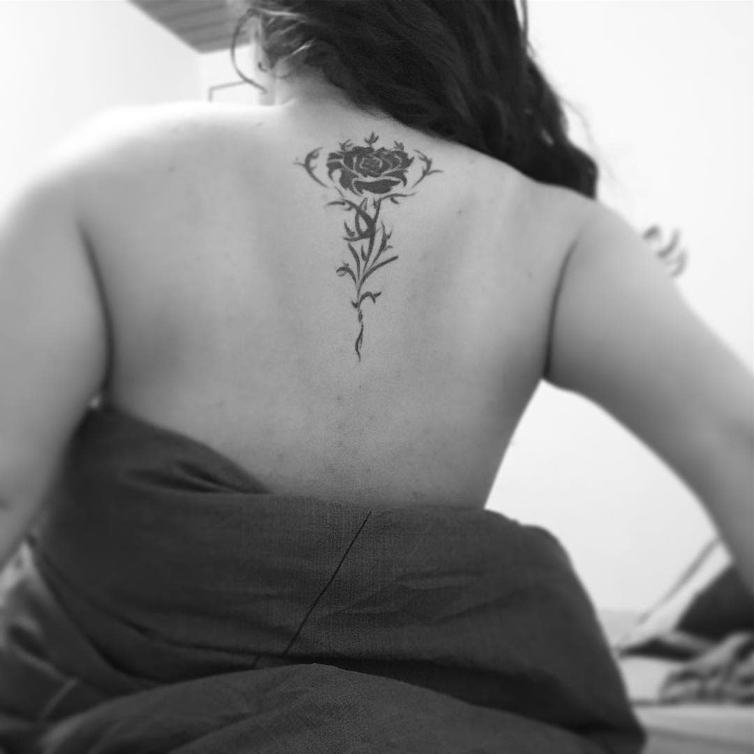 A woman with a tribal rose tattoo on her back