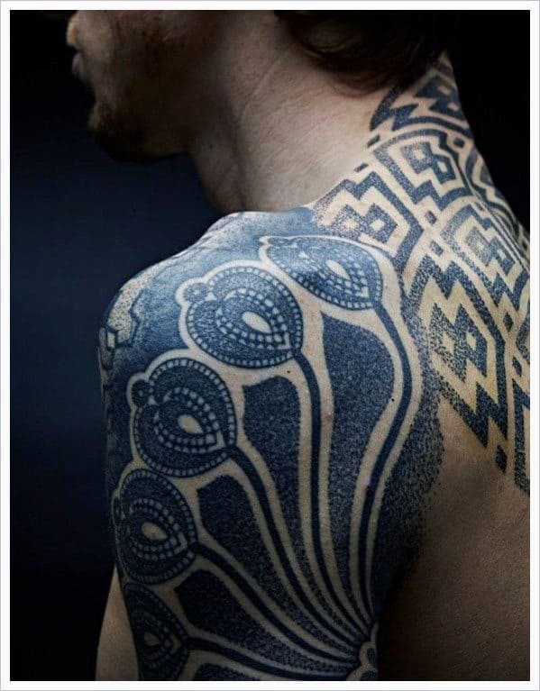 Man's back and shoulder with intricate geometric and patterned tattoos
