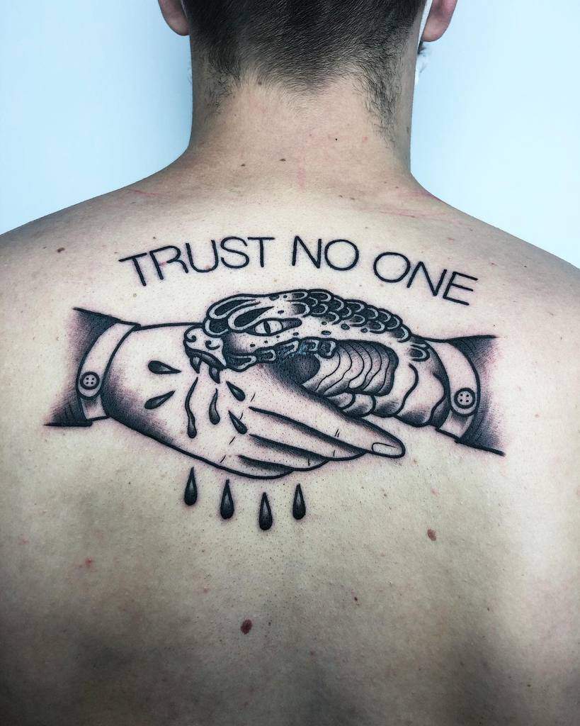 Back tattoo of a handshake with a snake, dripping blood, and the words "Trust No One" above it