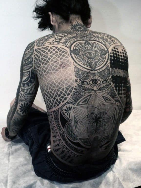 Person with intricate geometric and mandala tattoos covering their back and upper arms